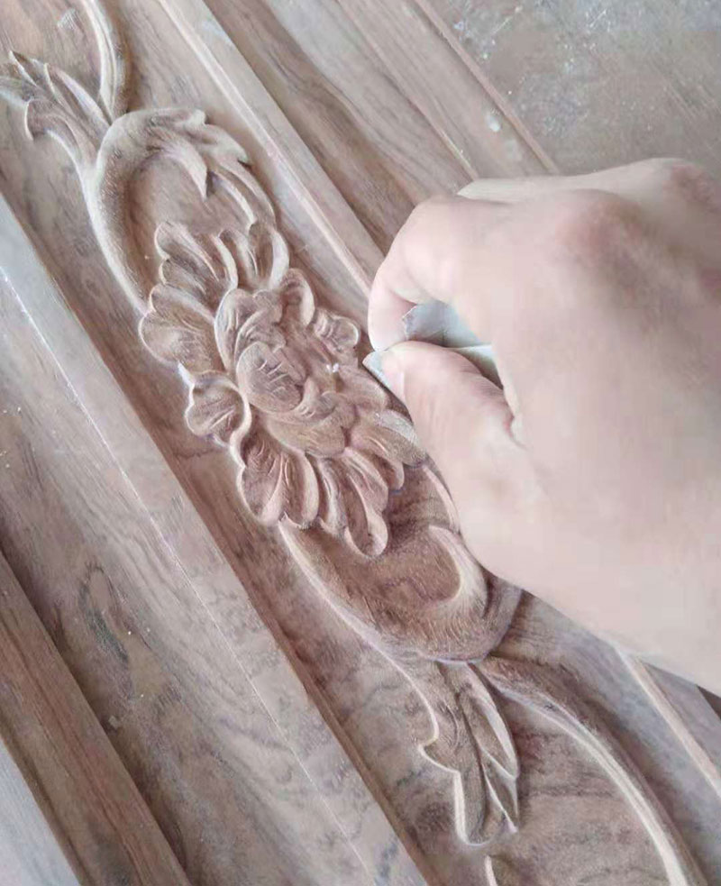雕刻师傅对中式花纹的局部细节擦拭