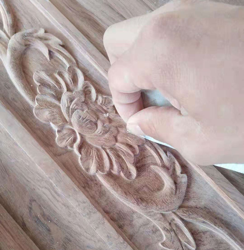 雕刻师傅对中式花纹的局部细节擦拭
